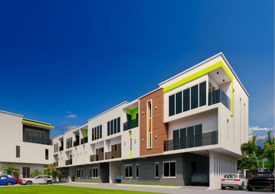 The terrace row at Ewang Estate, Abeokuta: six three-storey homes in white render with lime-lined balcony soffits and individual car garages at ground level.